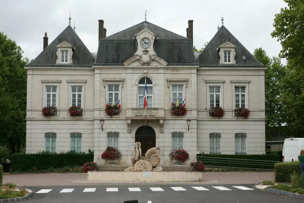 Façade d'une mairie française avec le drapeau tricolore au balcon